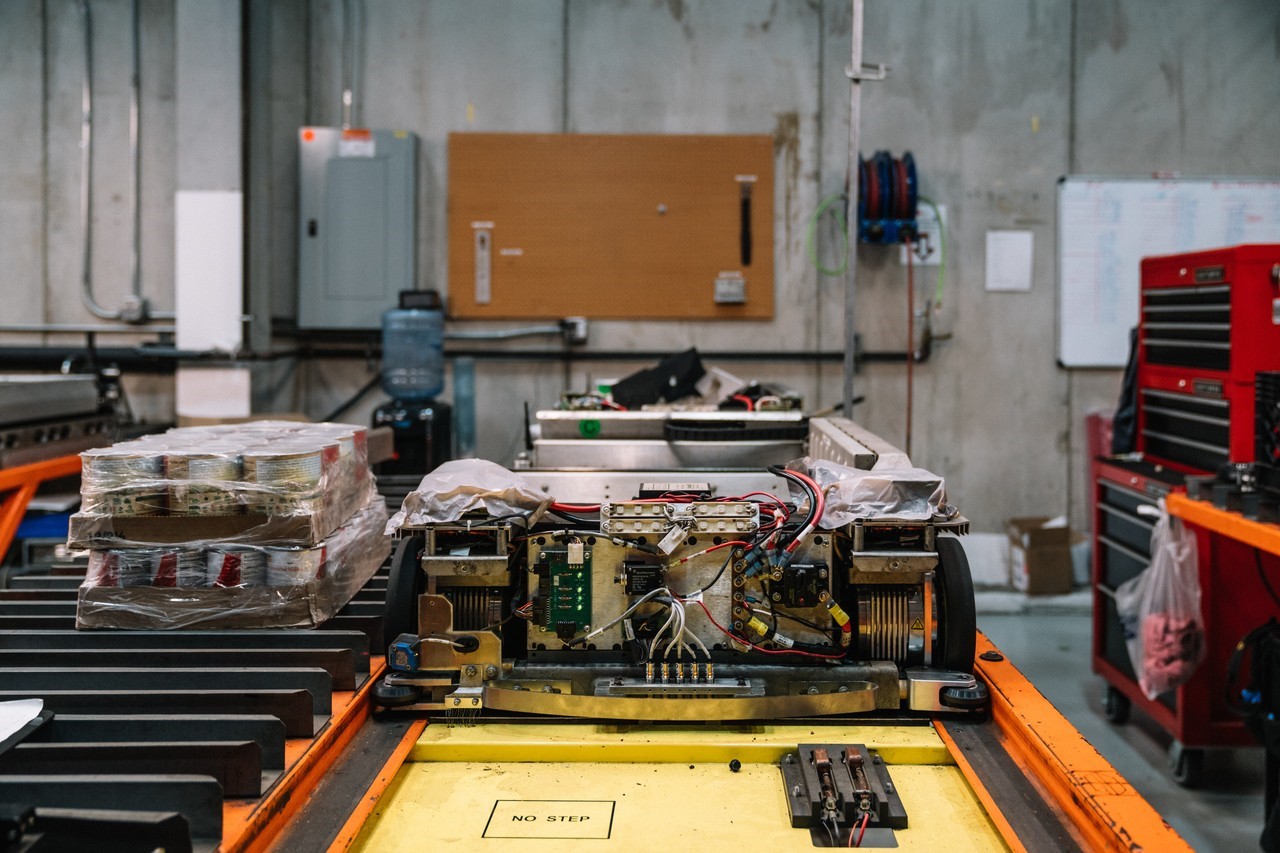 When a Symbotic robot is ‘sick’ or malfunctioning, it takes itself out of the storage system and alerts technicians to conduct repairs or maintenance. Here, a robot is serviced at the Newburgh, N.Y., facility. PHOTO: MICHAEL RUBENSTEIN FOR THE WALL STREET JOURNAL